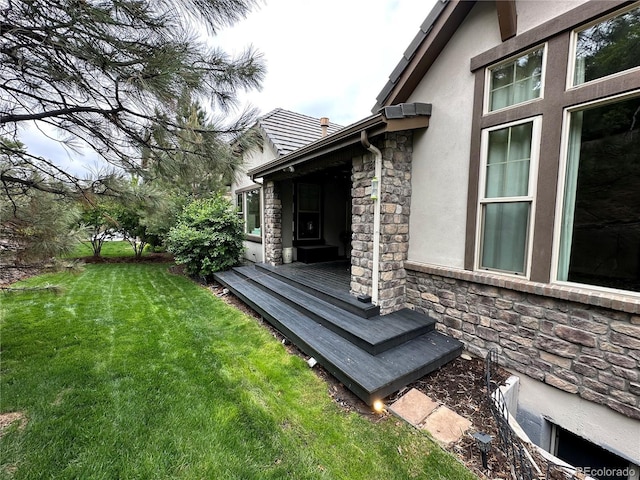 6875 Northstar Ct, Castle Rock, CO 80108 - view of home's exterior with stone siding, stucco siding, a lawn, and a deck