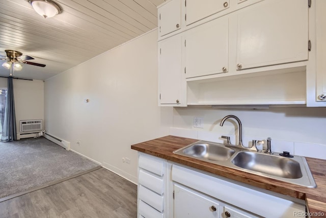 kitchen featuring butcher block countertops, a sink, white cabinetry, baseboard heating, and open shelves