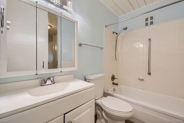 full bathroom with vanity, tiled shower / bath combo, and toilet