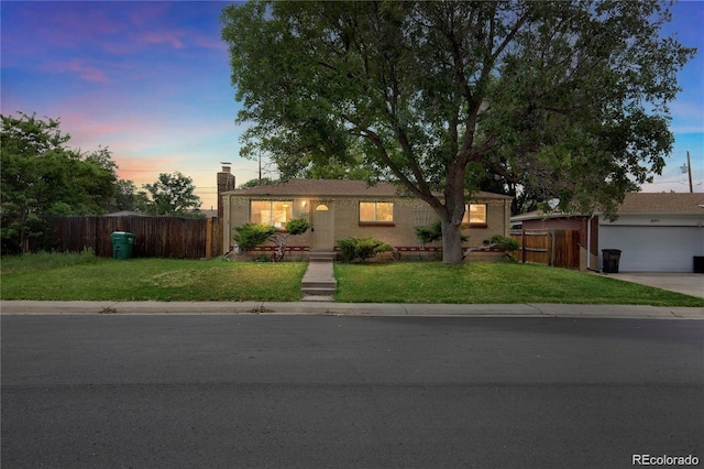 ranch-style home with a garage, concrete driveway, a front lawn, and fence