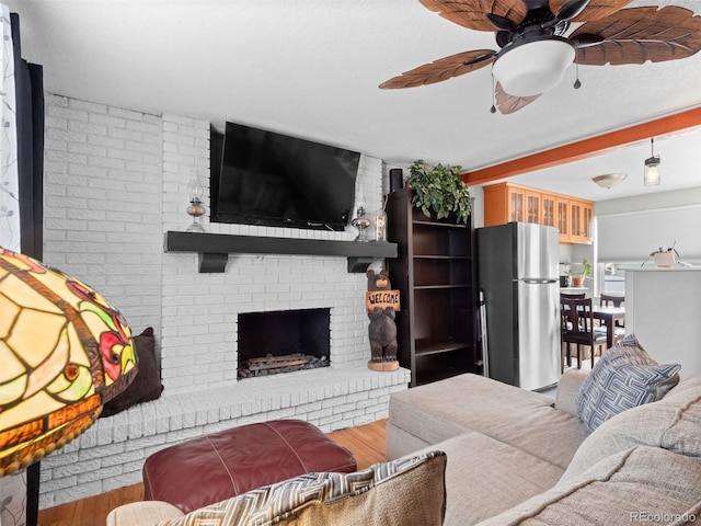 living area with a ceiling fan, a fireplace, and wood finished floors