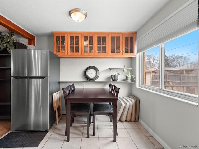 dining room featuring baseboards and light tile patterned floors