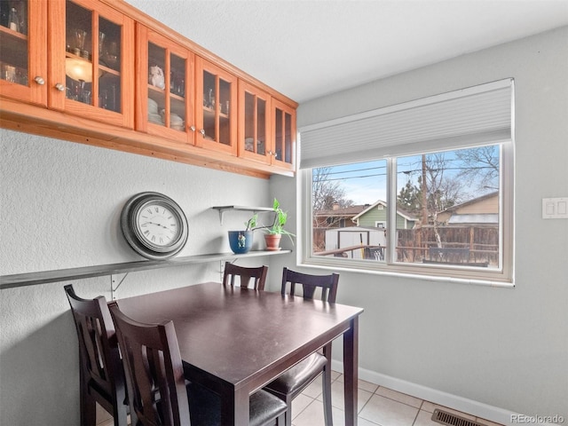 dining area featuring light tile patterned floors, visible vents, and baseboards