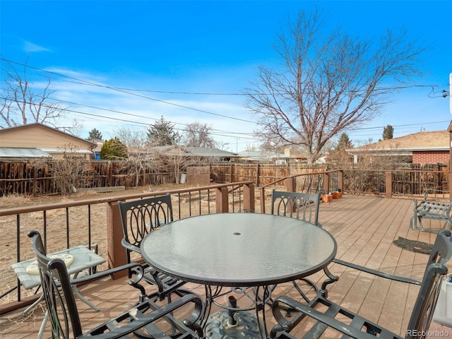 wooden terrace with outdoor dining area and a fenced backyard