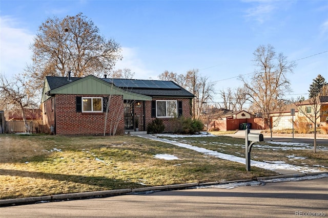 view of front of property featuring solar panels and a front yard