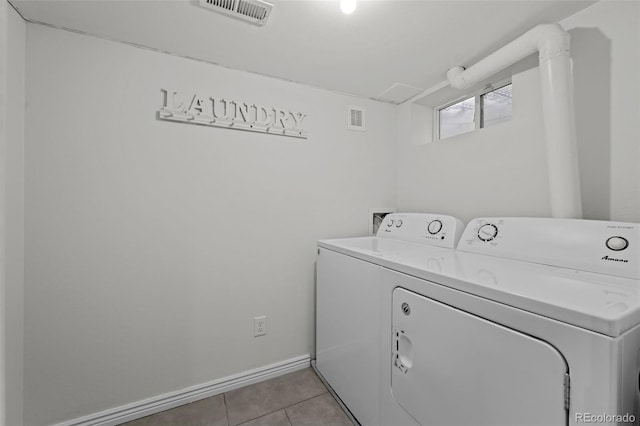 laundry room featuring separate washer and dryer and light tile patterned floors