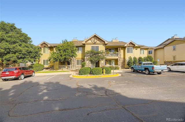 10467 W Hampden Ave Unit 204, Lakewood, CO 80227 - view of front of home featuring uncovered parking and stone siding