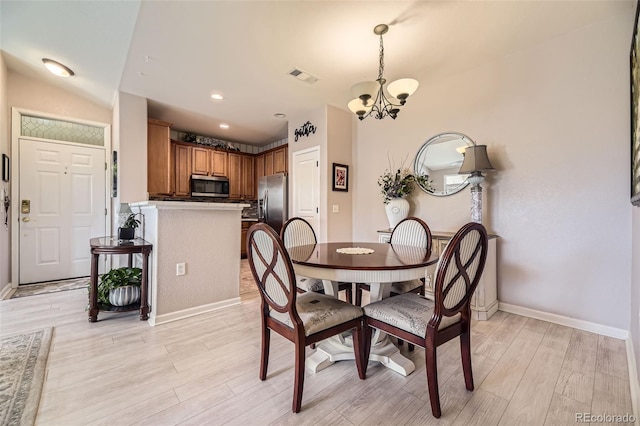 10467 W Hampden Ave Unit 204, Lakewood, CO 80227 - dining room featuring a chandelier and light wood-type flooring