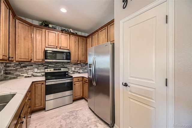 10467 W Hampden Ave Unit 204, Lakewood, CO 80227 - kitchen featuring appliances with stainless steel finishes, brown cabinetry, tasteful backsplash, and recessed lighting
