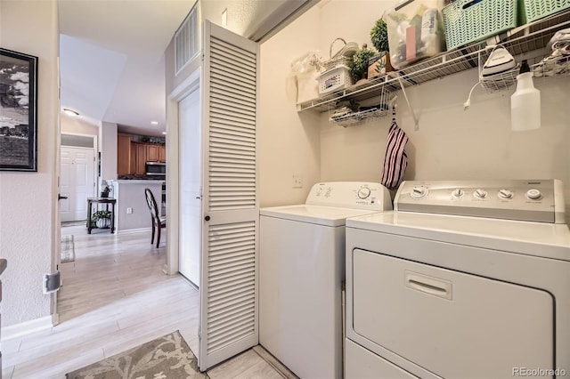 10467 W Hampden Ave Unit 204, Lakewood, CO 80227 - laundry room featuring washer and dryer and light wood-style flooring