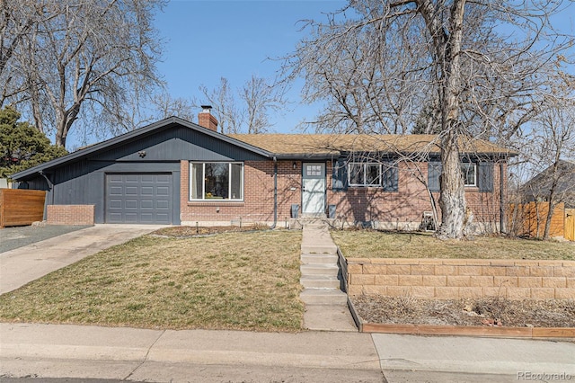 ranch-style home with a front yard, a chimney, concrete driveway, and brick siding