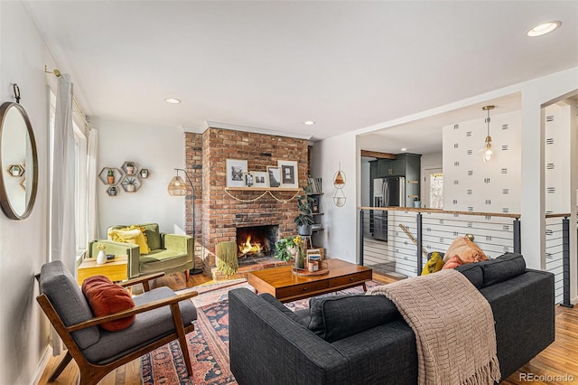 living area with light wood-type flooring, a fireplace, and recessed lighting