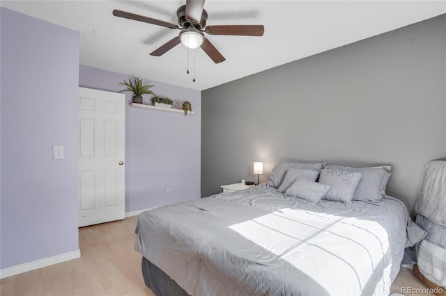 bedroom featuring light wood-style flooring, ceiling fan, and baseboards