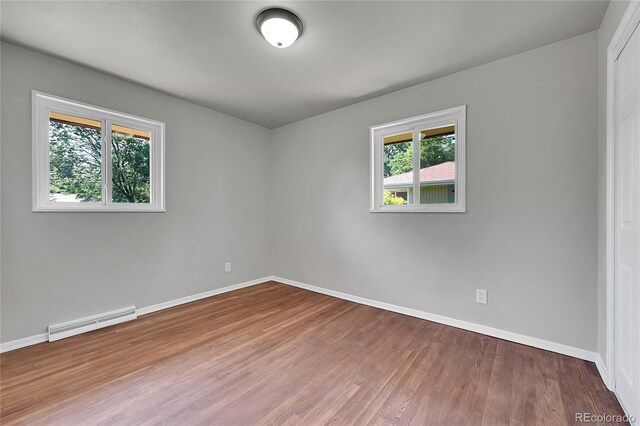 426 Kenton St, Aurora, CO 80010 - spare room with a baseboard radiator, plenty of natural light, and wood finished floors