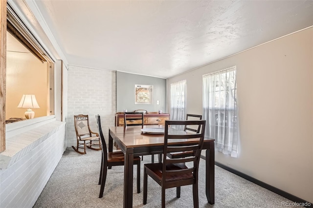 dining room with carpet, lofted ceiling, and ornamental molding