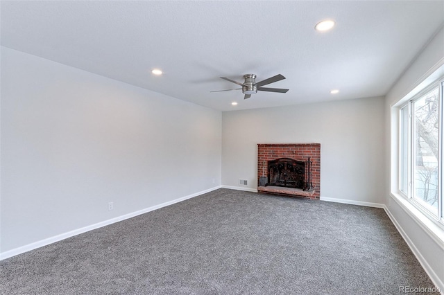 unfurnished living room featuring visible vents, baseboards, dark colored carpet, a brick fireplace, and recessed lighting