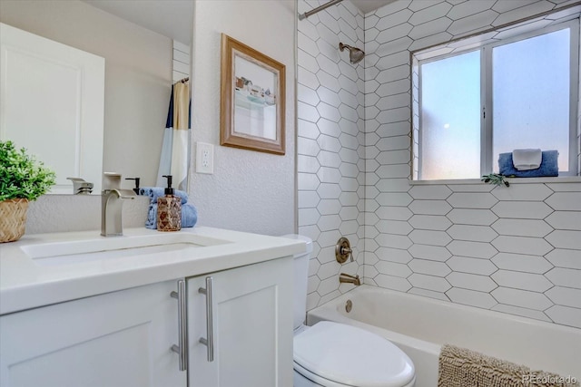 full bathroom featuring toilet, tiled shower / bath, and vanity