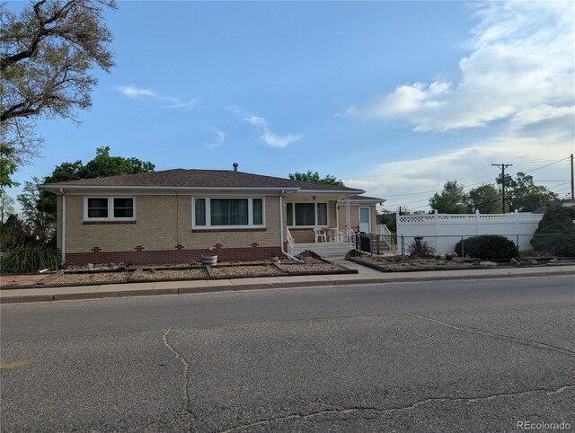 1009 Bush St, Brighton, CO 80601 - view of front of house featuring fence and brick siding