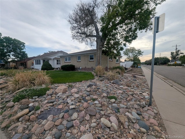 1009 Bush St, Brighton, CO 80601 - view of side of home featuring a yard and brick siding