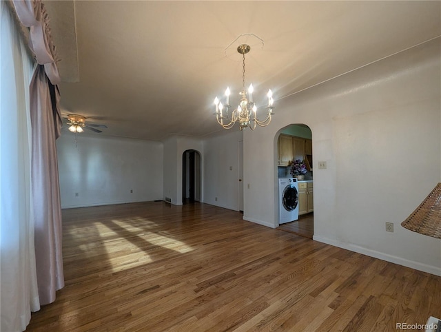 1009 Bush St, Brighton, CO 80601 - spare room with washer / clothes dryer, arched walkways, wood finished floors, and a chandelier