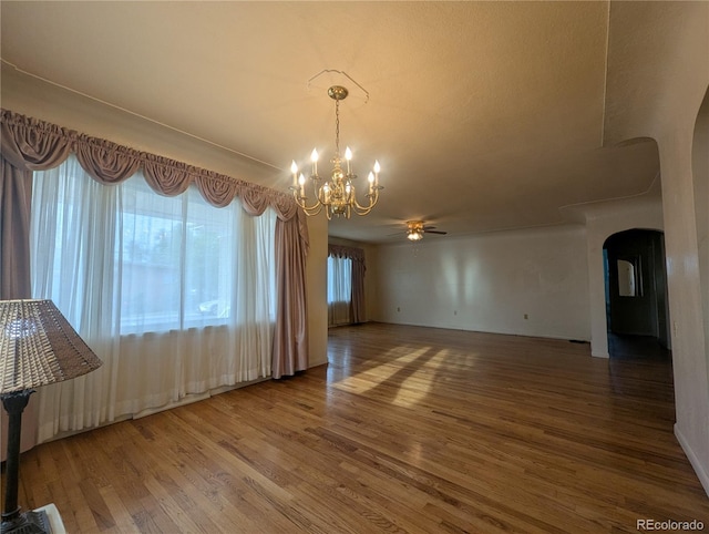 1009 Bush St, Brighton, CO 80601 - empty room featuring arched walkways, a chandelier, a ceiling fan, and wood finished floors