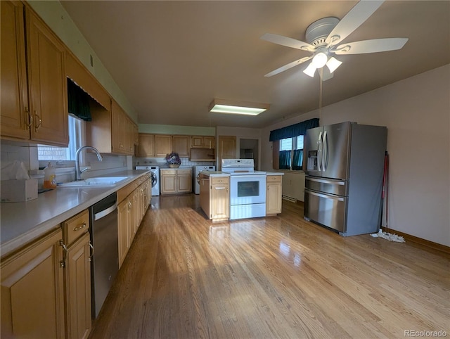 1009 Bush St, Brighton, CO 80601 - kitchen with stainless steel appliances, washer / clothes dryer, a sink, and light wood-style flooring