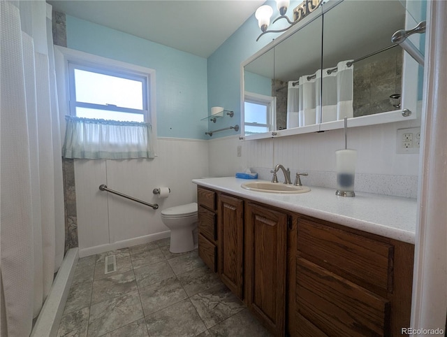 1009 Bush St, Brighton, CO 80601 - full bathroom featuring vanity, toilet, a wainscoted wall, and curtained shower