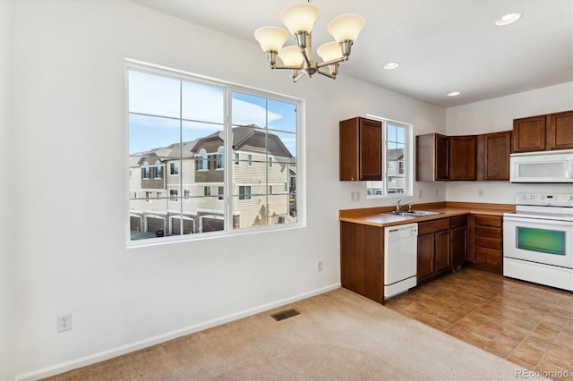 kitchen featuring decorative light fixtures, white appliances, a notable chandelier, sink, and light colored carpet