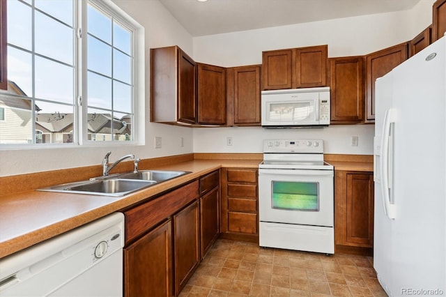 kitchen featuring white appliances and sink