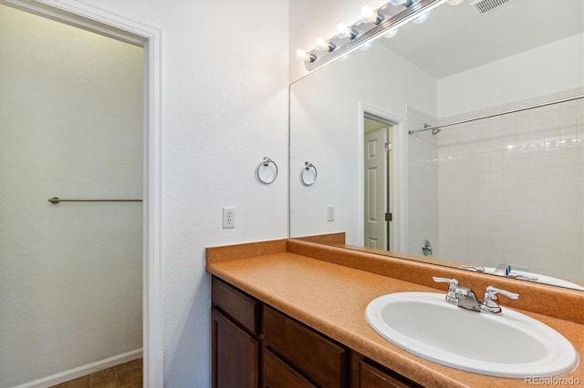 bathroom featuring tiled shower, vanity, and tile patterned floors