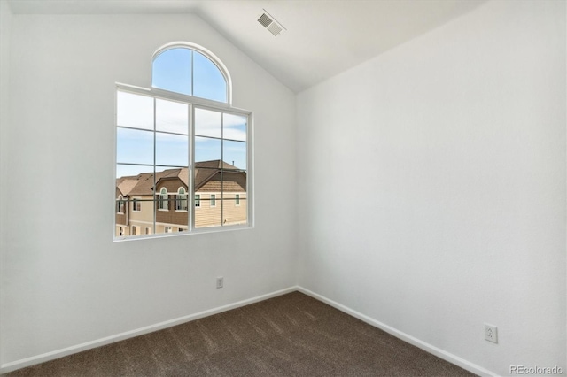 carpeted empty room featuring vaulted ceiling