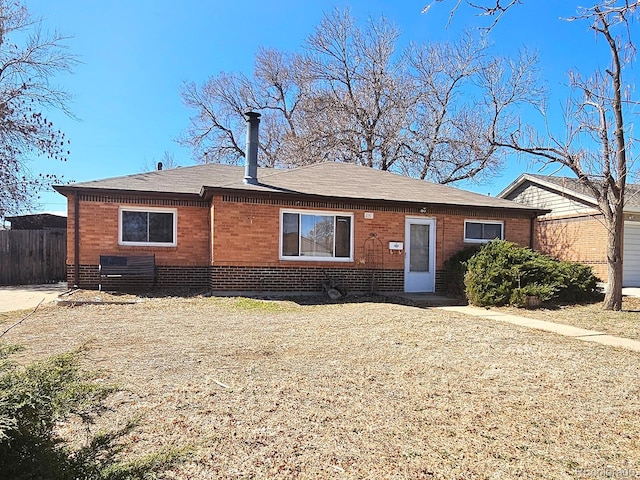 view of front facade featuring fence and brick siding