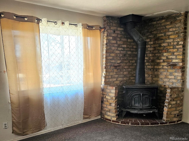 interior space with a wood stove and carpet floors