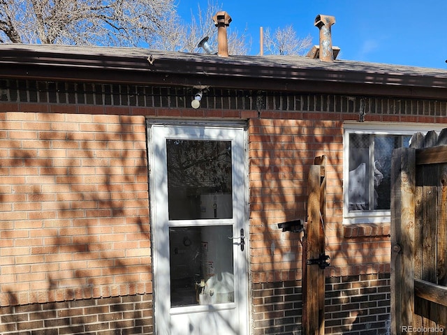 view of home's exterior featuring brick siding and roof with shingles