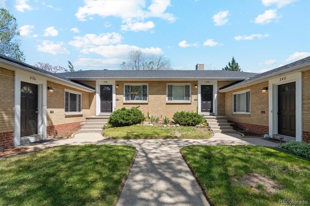 236 S Clarkson St, Denver, CO 80209 - view of front of home with brick siding, a front yard, and a chimney
