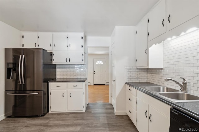 236 S Clarkson St, Denver, CO 80209 - kitchen featuring stainless steel fridge, black dishwasher, a sink, white cabinetry, and decorative backsplash