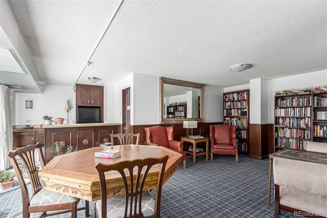 800 N Washington St Unit 804, Denver, CO 80203 - carpeted dining room featuring a textured ceiling, a wainscoted wall, and wood walls