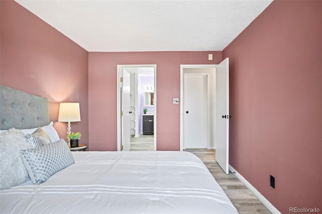 bedroom featuring baseboards and light wood-style flooring