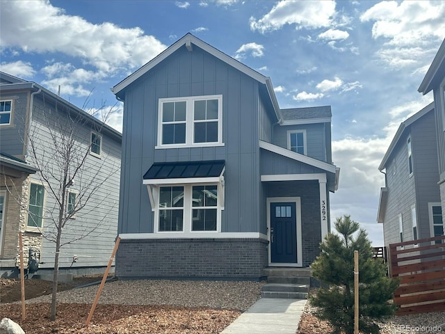 view of front of home featuring a standing seam roof, metal roof, board and batten siding, and brick siding