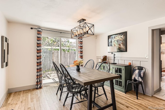 1271 Uinta St, Denver, CO 80220 - dining room featuring a chandelier, light wood-style flooring, and baseboards