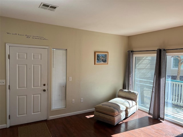 sitting room featuring baseboards, visible vents, and wood finished floors