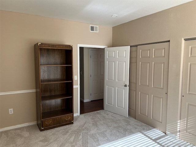 unfurnished bedroom with carpet floors, baseboards, and visible vents