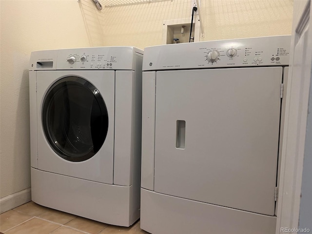 clothes washing area featuring laundry area, washing machine and dryer, and light tile patterned floors