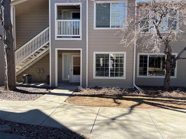 back of property with stairs and central air condition unit