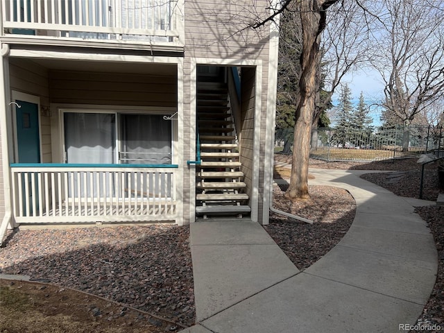 view of side of home featuring fence and a balcony