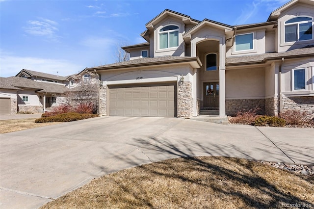 view of front of property featuring stone siding, driveway, and stucco siding