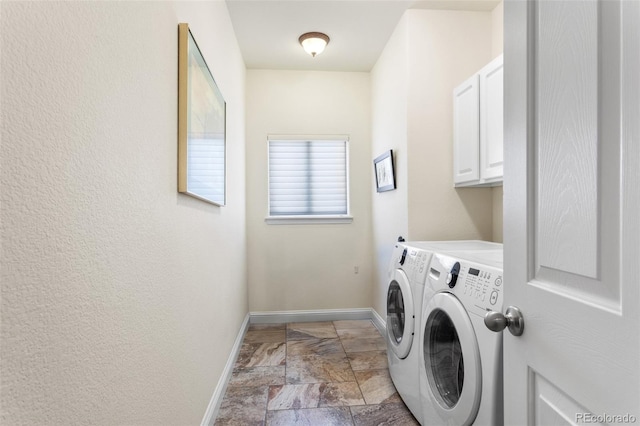 clothes washing area with stone finish flooring, cabinet space, independent washer and dryer, and baseboards