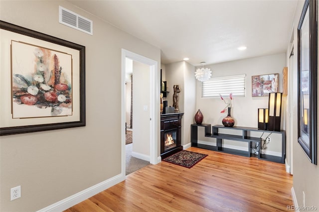 interior space with a notable chandelier, recessed lighting, wood finished floors, visible vents, and baseboards