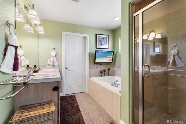 full bathroom with double vanity, a stall shower, tile patterned floors, a garden tub, and a sink