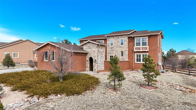 traditional-style house with stone siding and fence